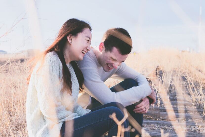 Happy Multicultural couple, Asian Female, White Male sitting in a field | Couple after therapy Columbus Ohio