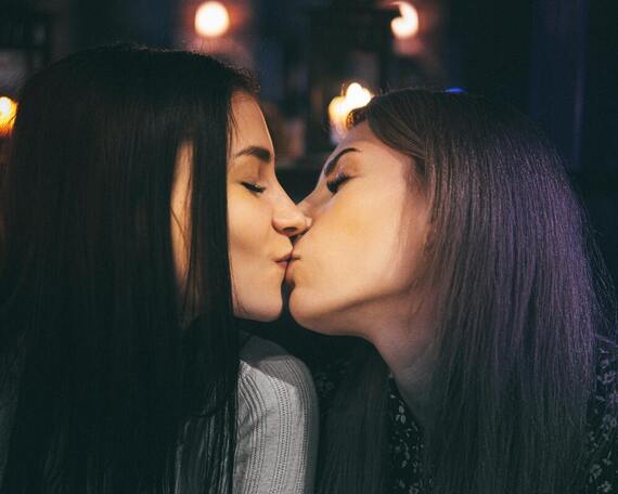 Couple with two women with brown hair kissing
