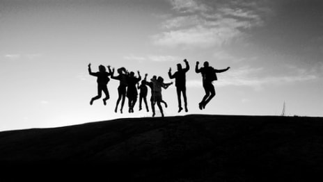 Image of human figures jumping in unison in black and white | Family