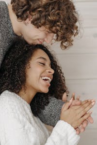 Happy couple embracing indoors, showcasing affection and joy in a warm setting.
